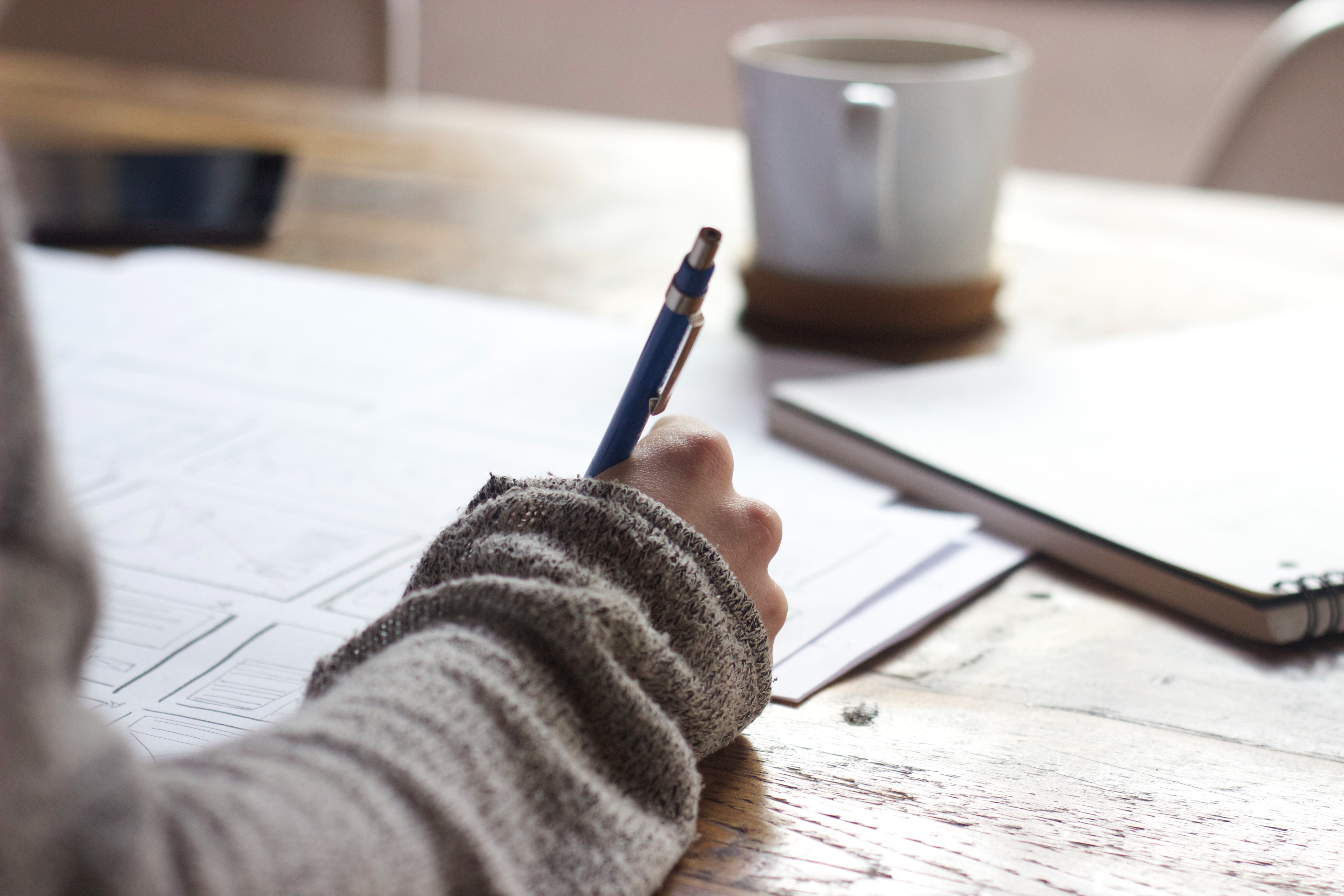 person holding pen whilst making wireframes