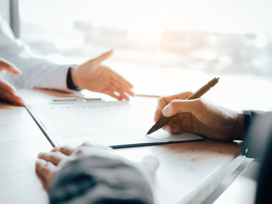 people conducting business using notepad and pen