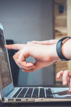 person pointing at laptop screen