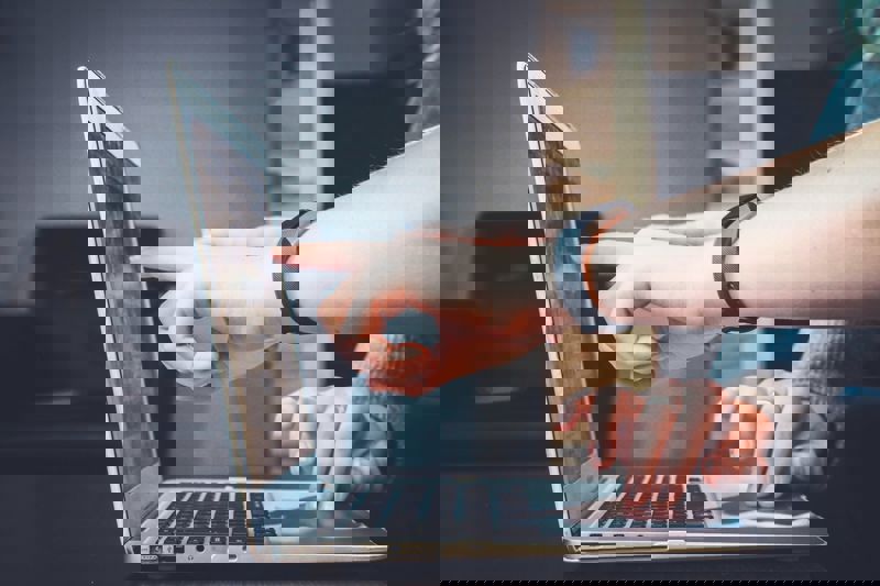 person pointing at laptop screen