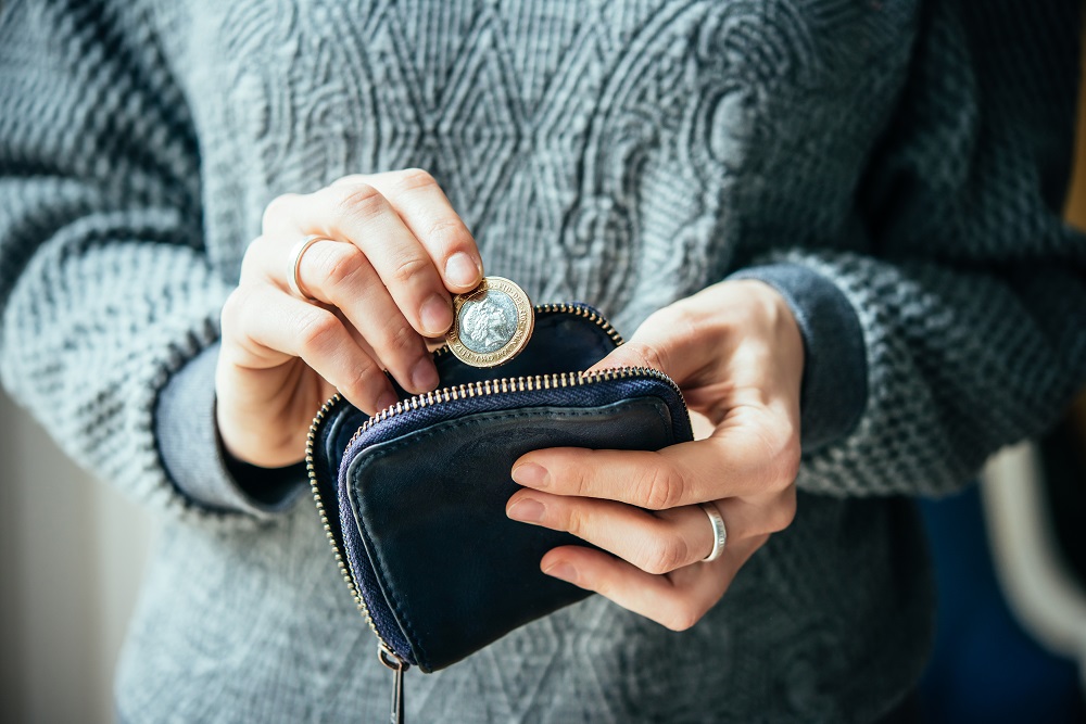 pound coin being put into a purse