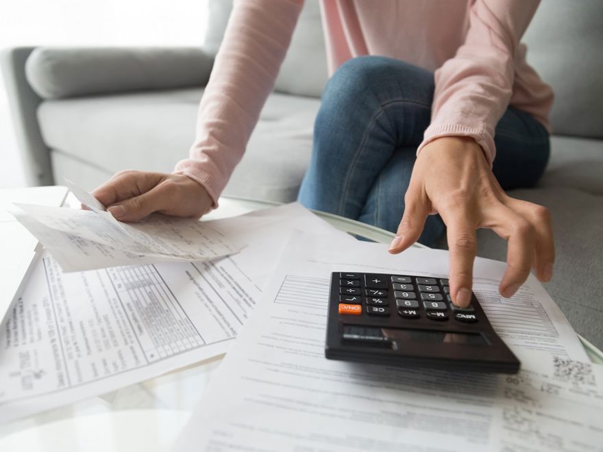 person with bills and calculator