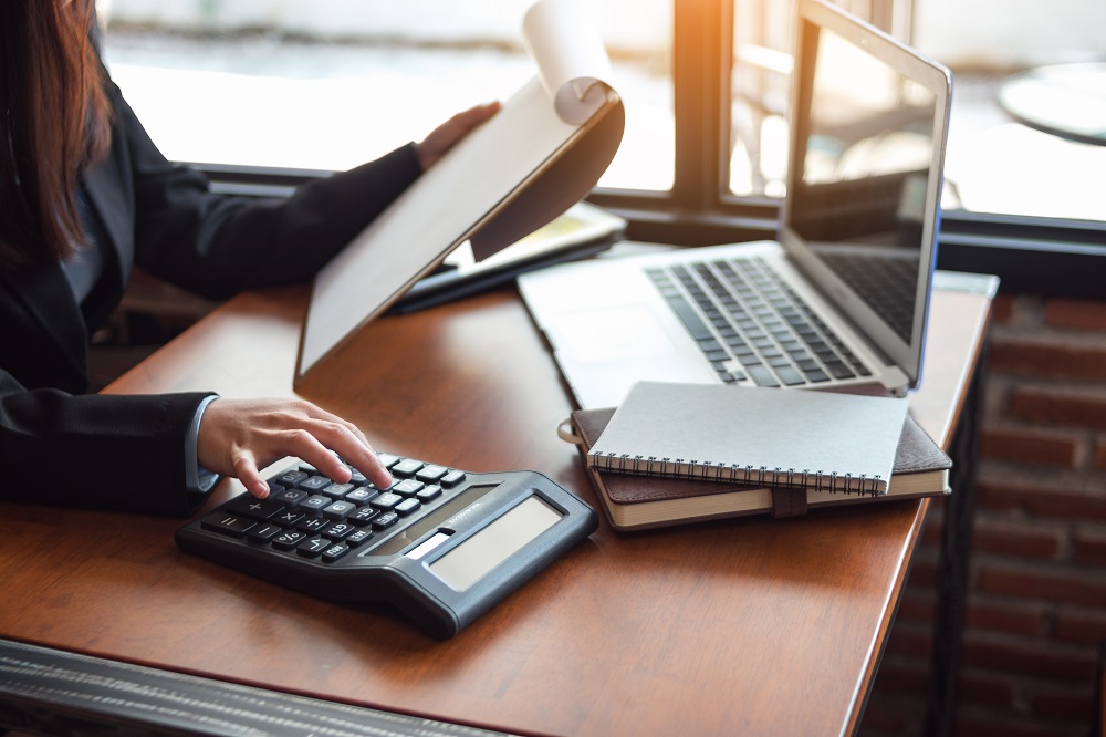 woman at desk with laptop and calculator